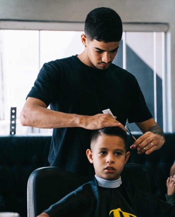 Barbeiro da Menz's Barbearia cortando o cabelo de um cliente